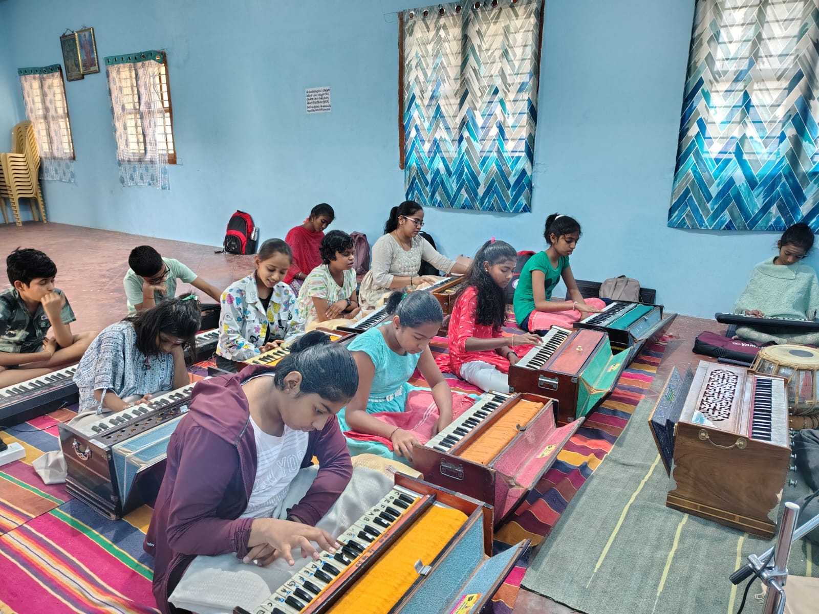 Students practising Hindustani vocal music on harmoniums